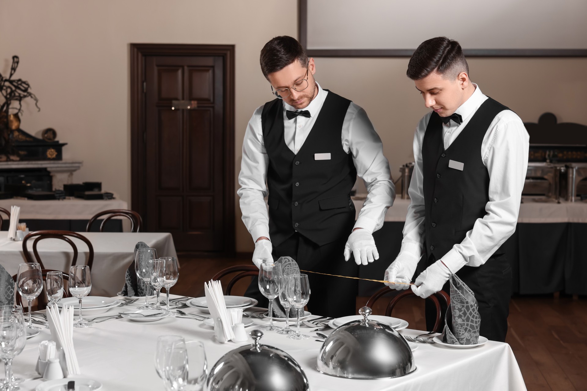 People setting table during professional butler courses in restaurant