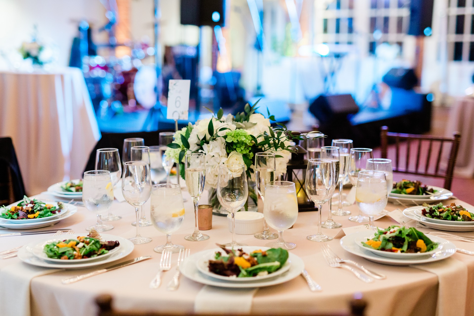 Table with Plated Salads and Napkins and Wine Glasses