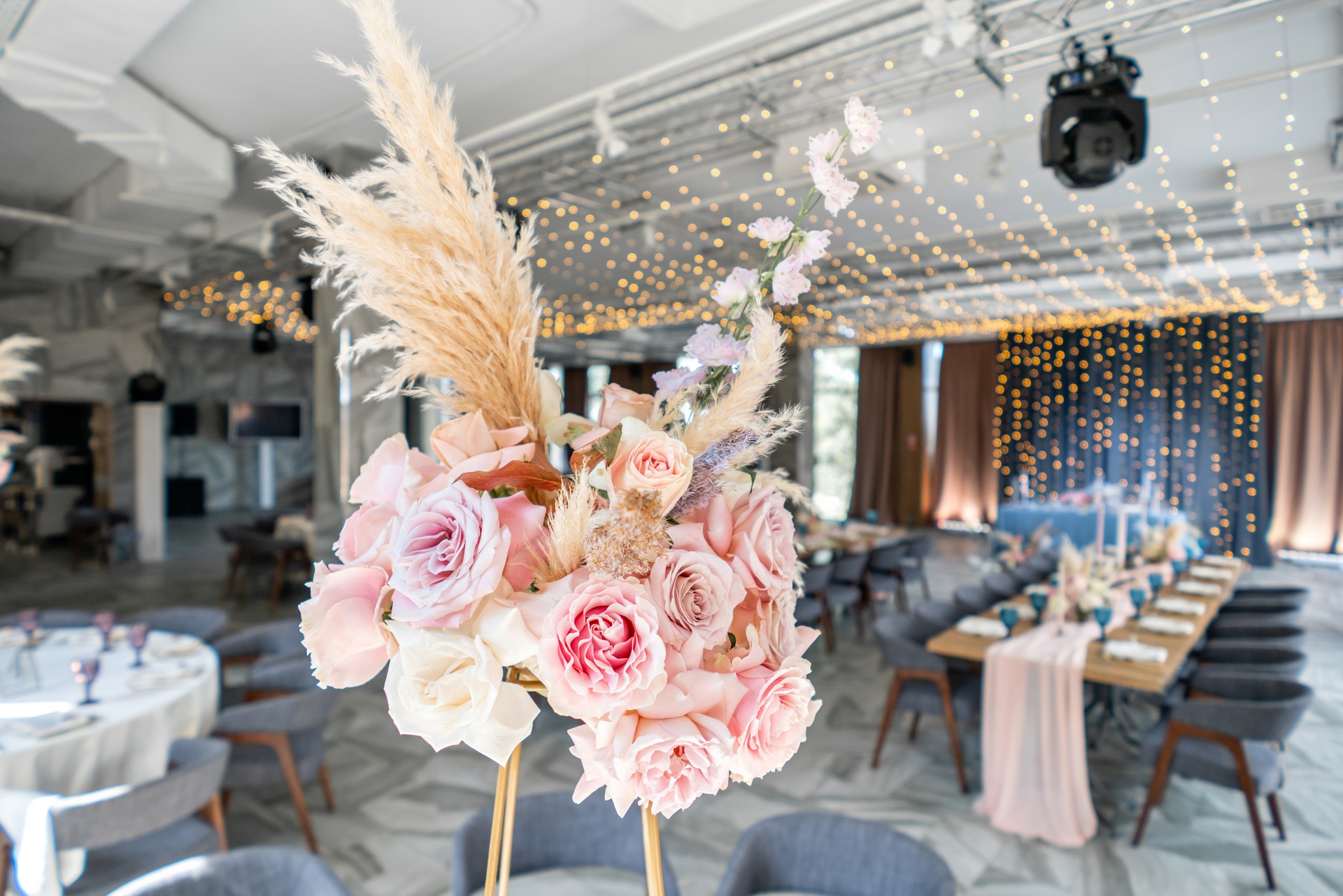 Wedding Banquet or gala dinner. The chairs and table for guests, served with cutlery and crockery. Covered with a pastel pink tablecloth runner. party lighted with garlands